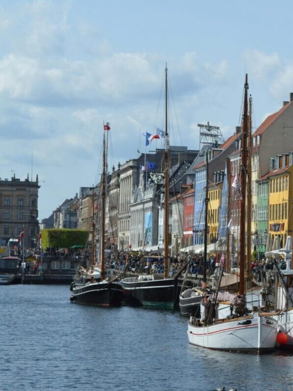 Vibrant waterfront scene of Nyhavn harbor with historic buildings and boats in Copenhagen.